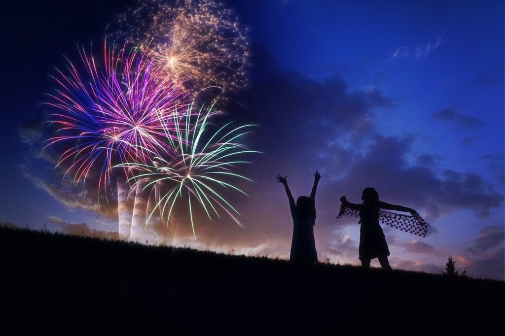 Fireworks with two children in silhouette.